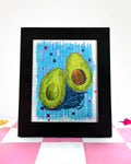art print of an avocado that was sliced in half on a checkered blue background.
