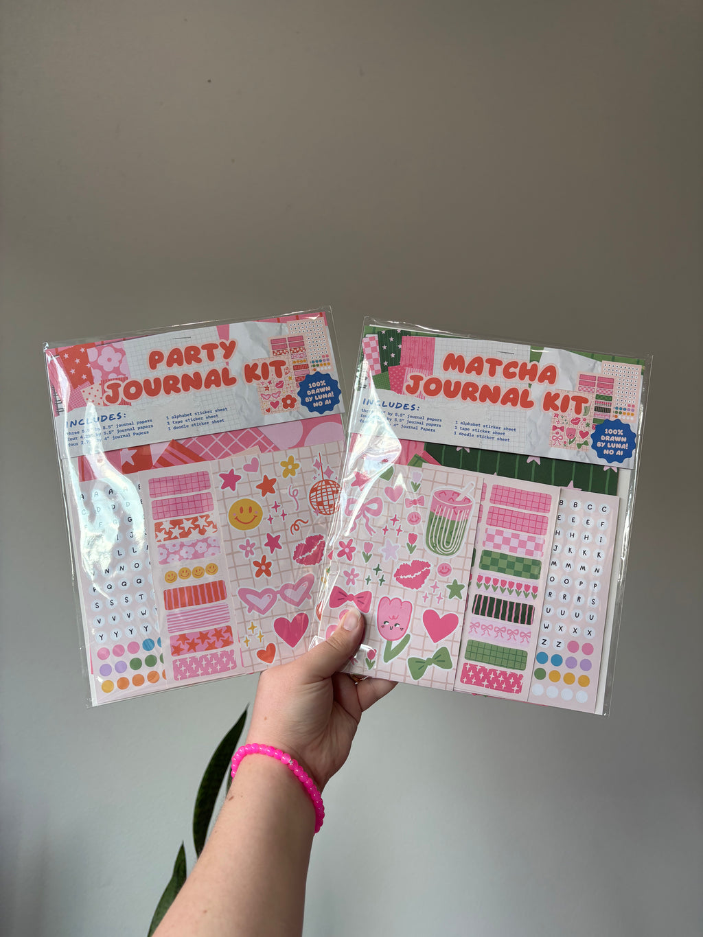 a hand holding up the party journal kit and matcha journal kit in their packages