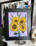 Artwork with yellow sunflowers on a pastel pink, purple, and blue background