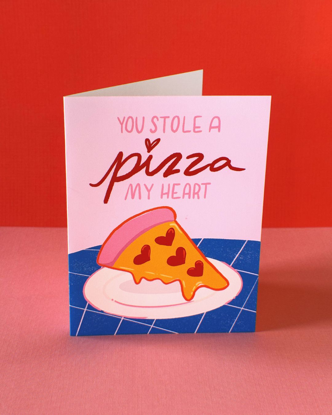 Greeting card that says "you stole a pizza my heart" with an illustrated pizza that has heart pepperonis and pink crust.